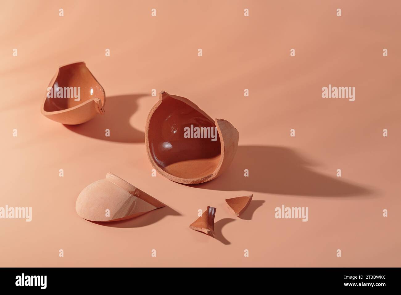 Details of broken ceramic cup on beige background Stock Photo - Alamy