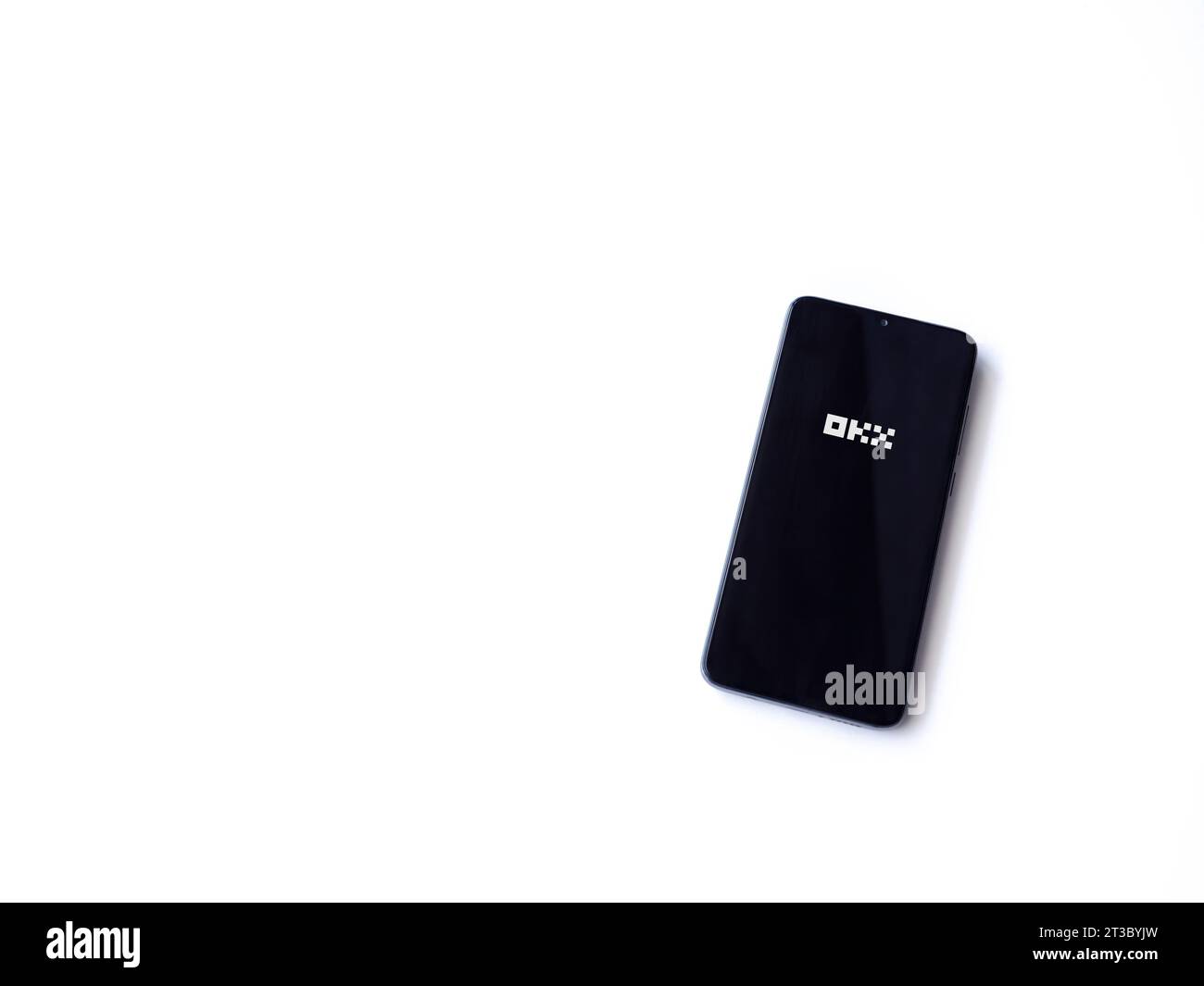 Lod, Israel - July 16,2023: OKX app launch screen on smartphone on white background. Top view flat lay with copy space. Stock Photo