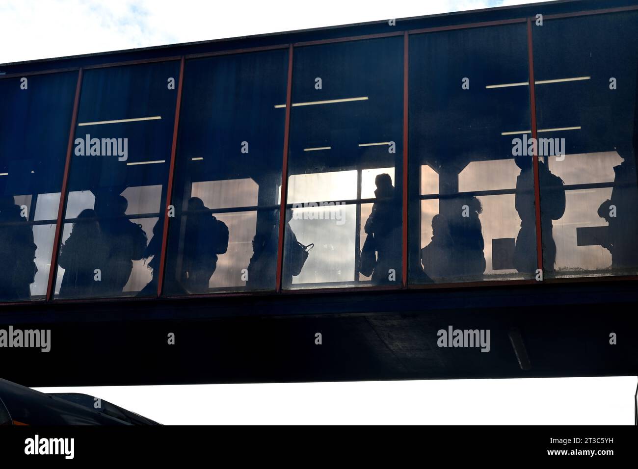 Silhouettes of people in crossing railway bridge at station, UK Stock Photo