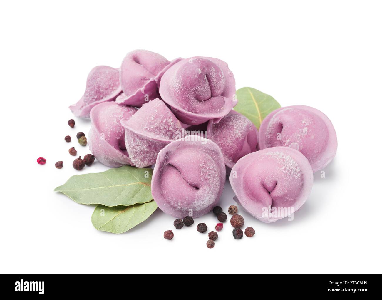 Purple raw dumplings with peppercorn and bay leaves on white background ...