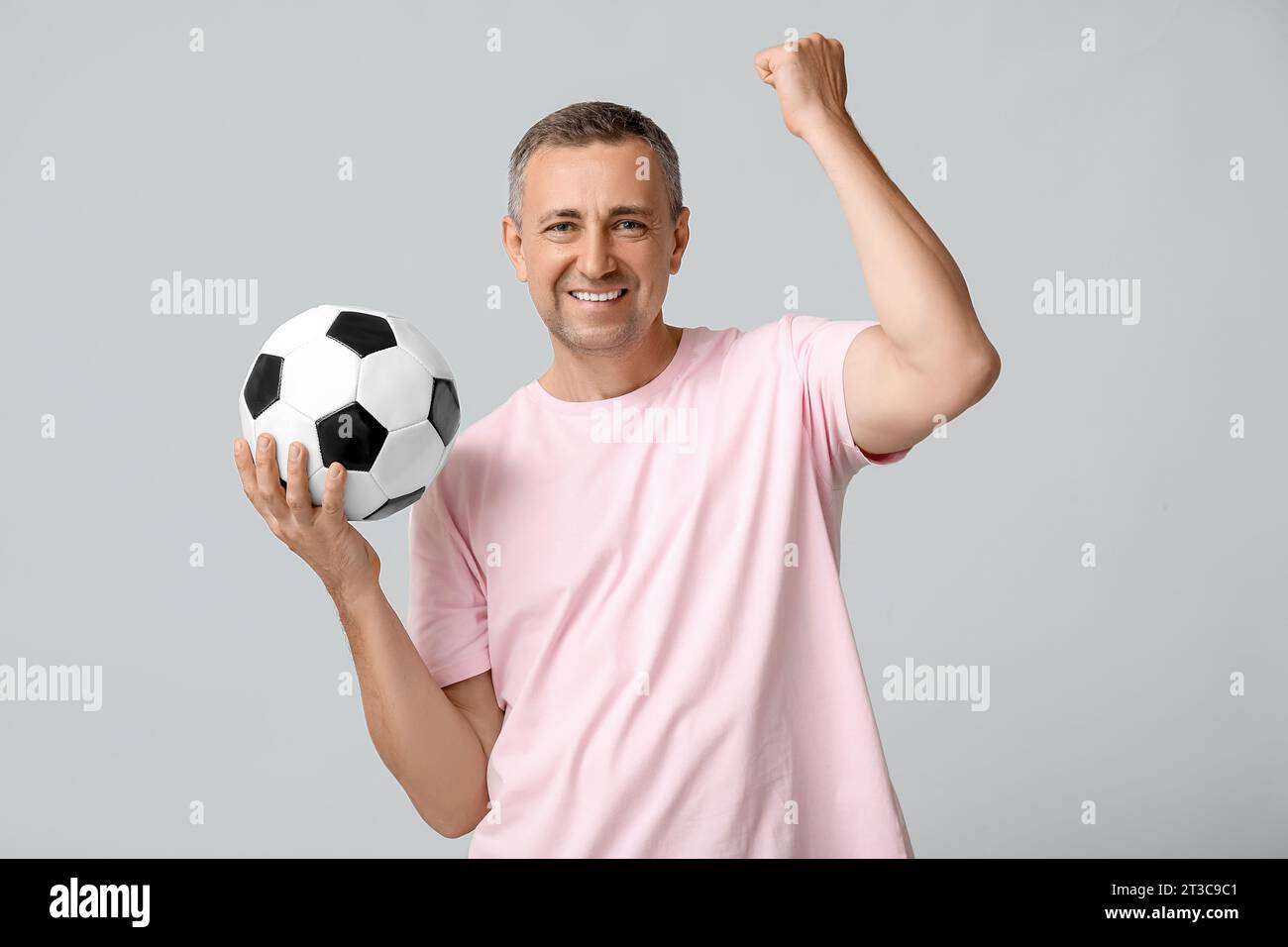 Happy handsome mature man with soccer ball on grey background Stock ...