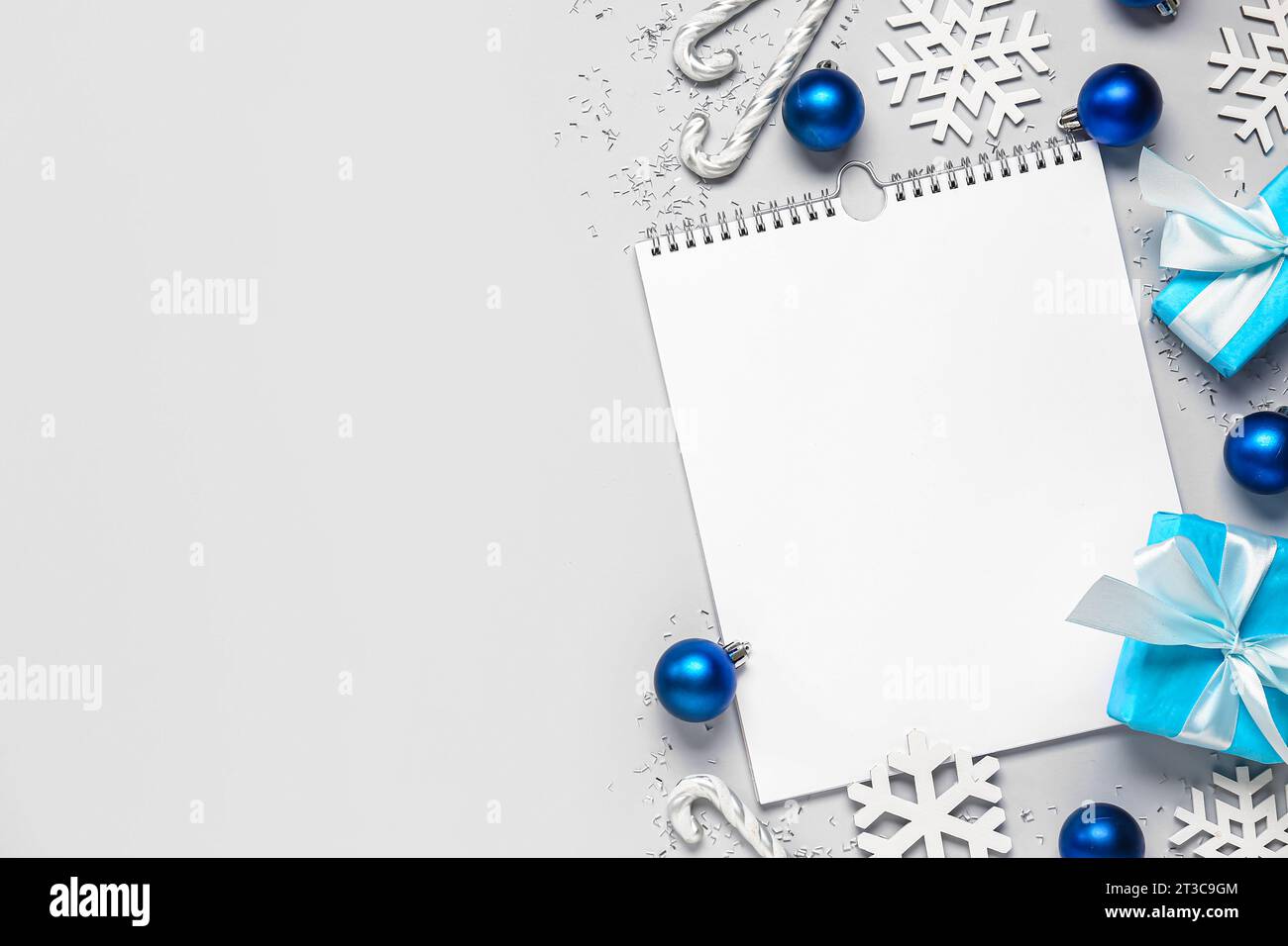 Blank paper calendar with gift boxes and Christmas decorations on grey ...