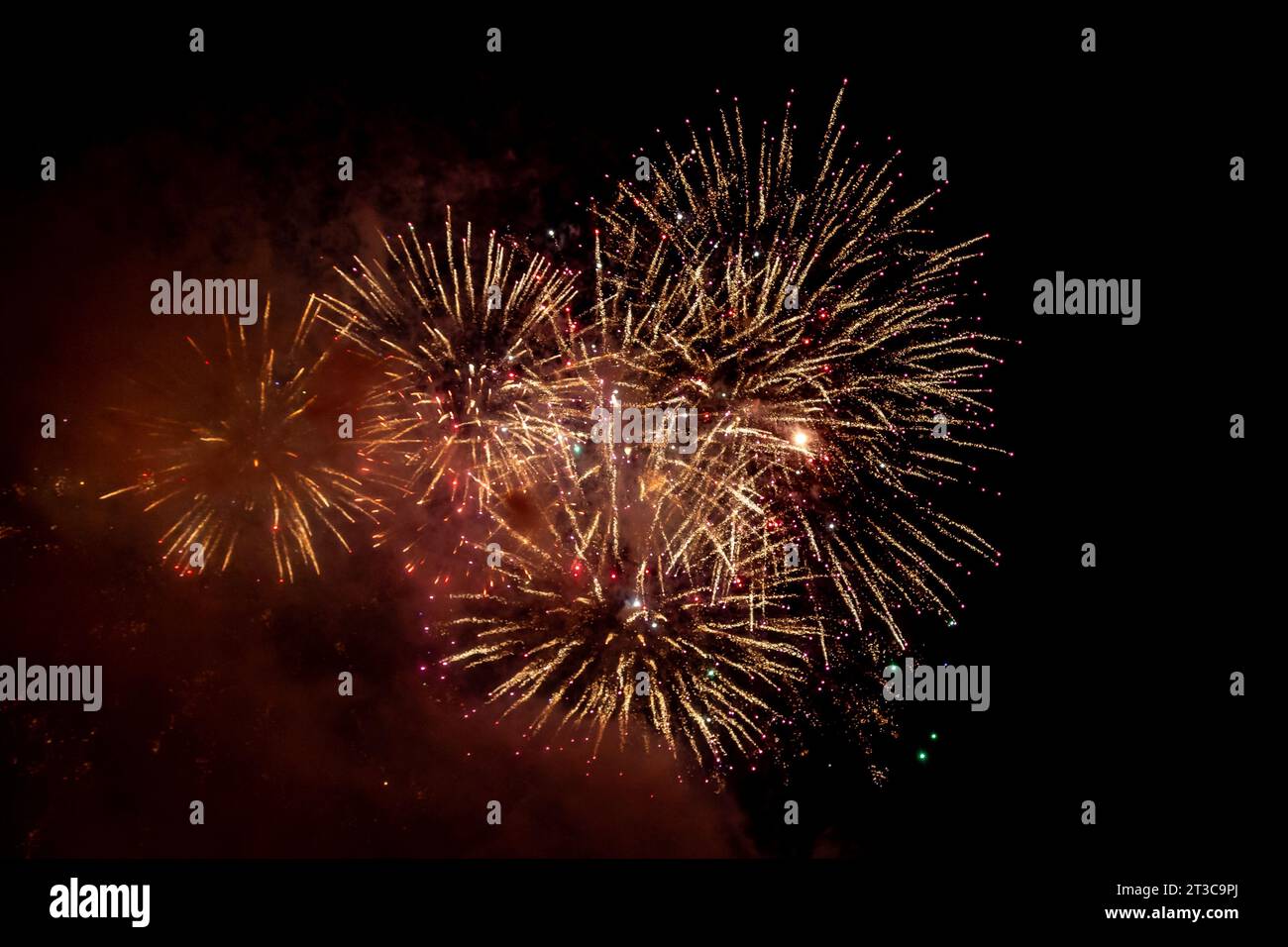 Looking up at exploding fireworks against a night sky Stock Photo