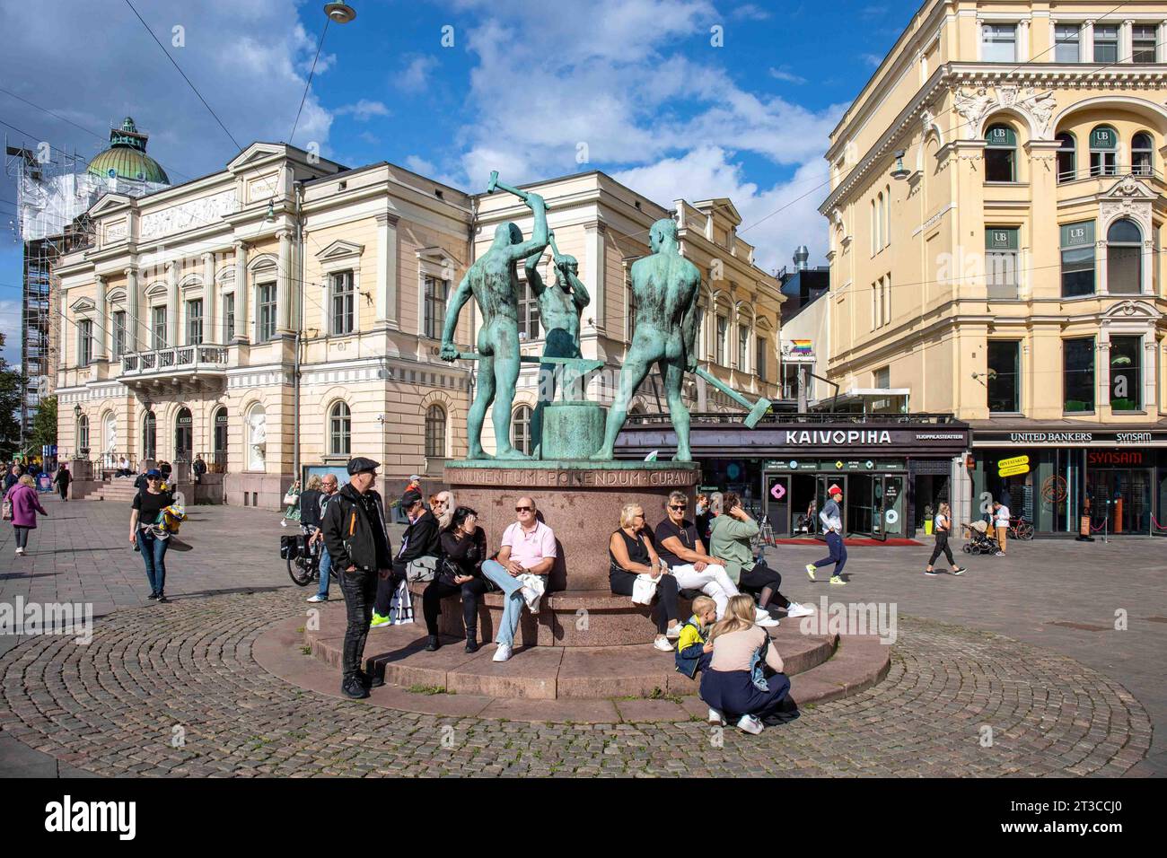 People sitting by Three Smiths Statue on a sunny early autumn day in Helsinki, Finland Stock Photo