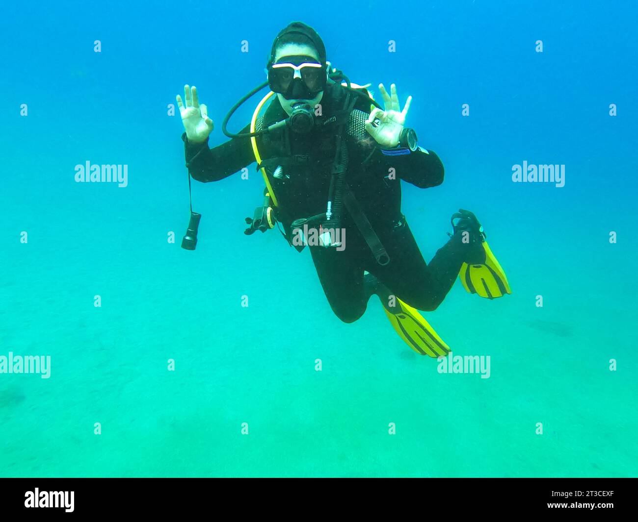 Woman scuba diver alone showing "Ok" signal underwater, "I am Ok