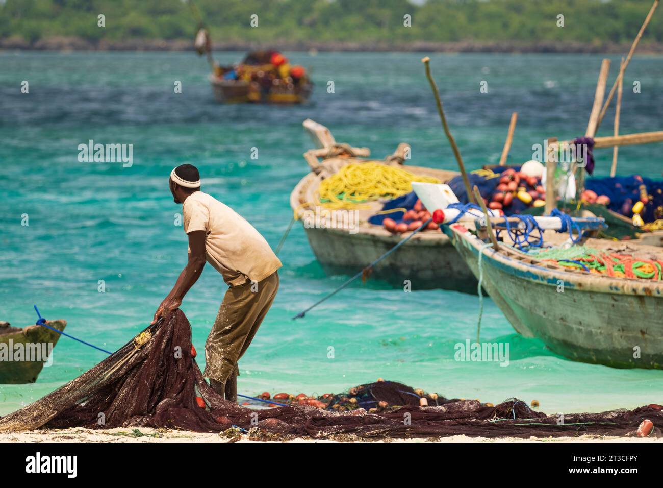 African fisherman catches fishing nets and looks out to sea, sunny day , Zanzibar, tanzania. Stock Photo