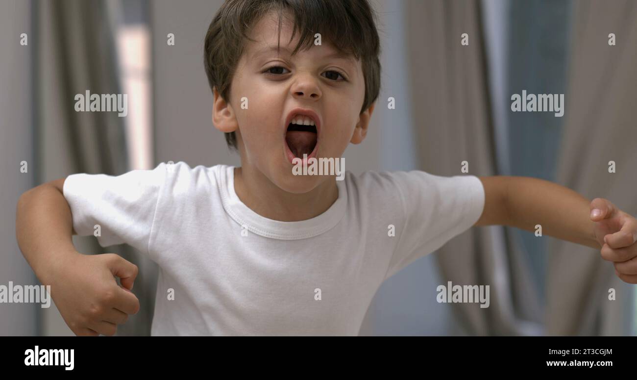 Intense Young boy venting anger in 800 fps slow-motion shout, angry kid yelling to camera Stock Photo