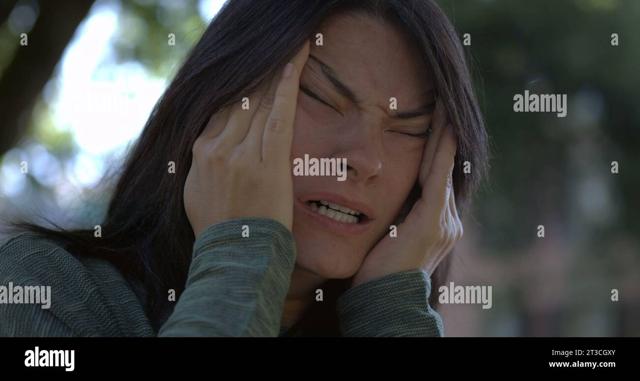 Exhausted woman in 30s rubs eyes and face in slowmotion, fatigue