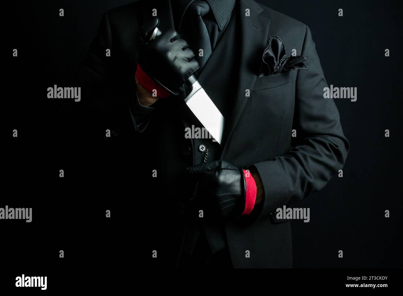 Portrait of Mysterious Man in Black Suit Pulling Knife Out of Jacket. Mafia Hitman or Gangster Stock Photo