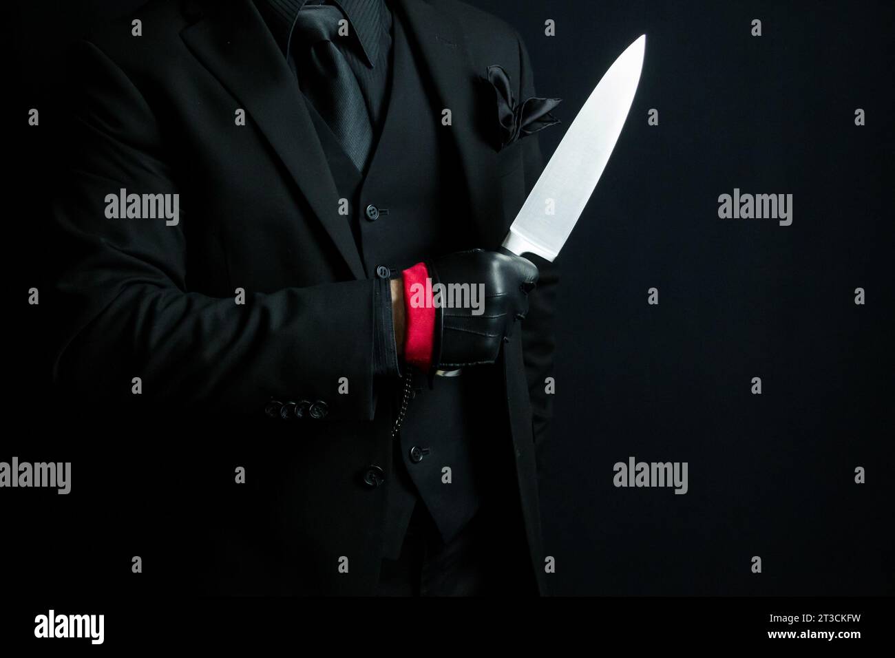 Portrait of Man in Dark Suit and Leather Gloves Holding Knife. Mafia Hit Man or Ruthless Gangster Stock Photo