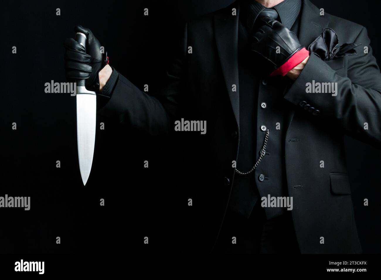 Portrait of Man in Dark Suit and Leather Gloves Holding Sharp Knife. Well Dressed Gentleman Killer. Mafia Hit Man in Stylish Suit. Stock Photo
