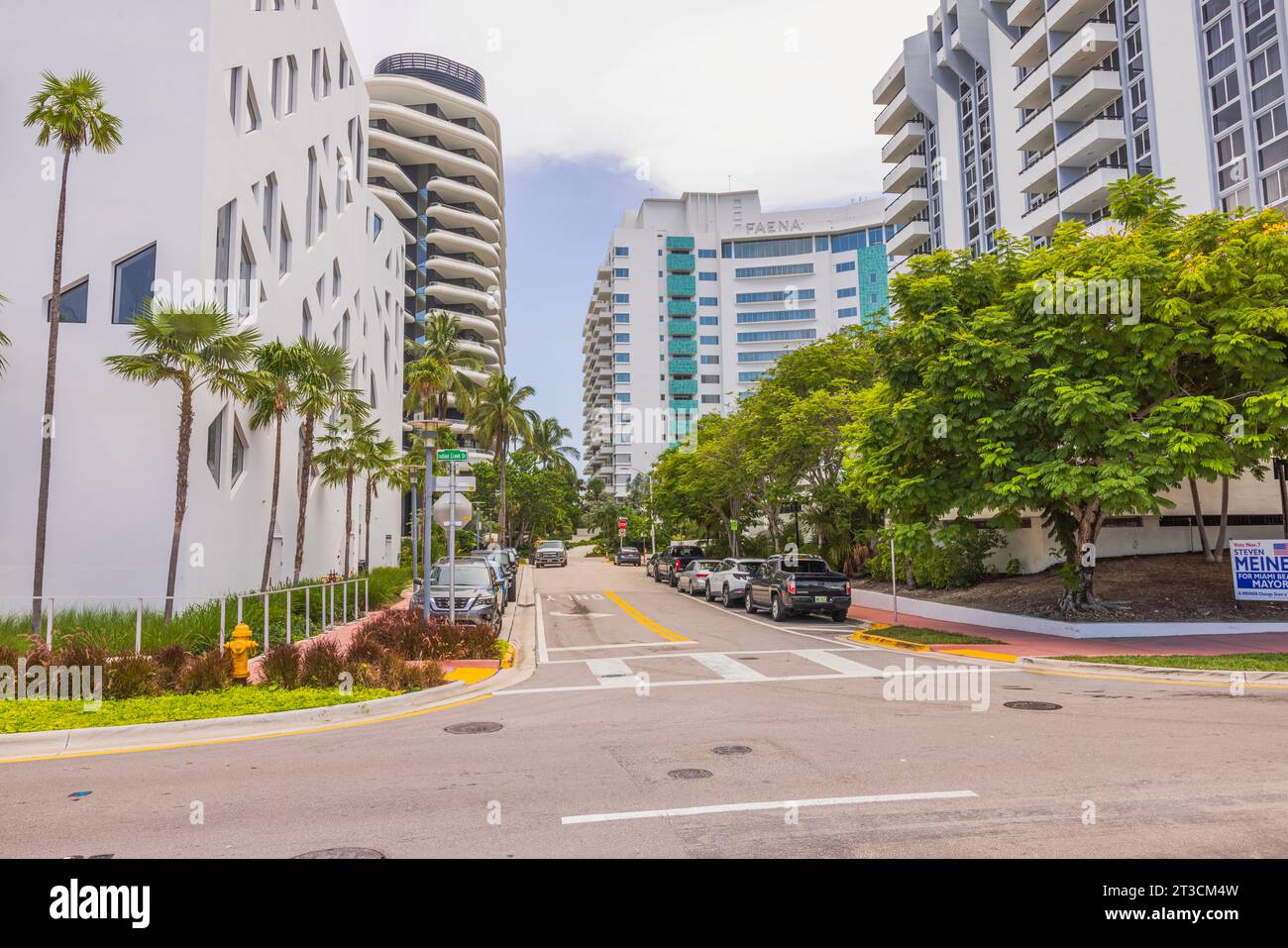 Beautiful street view in Miami Beach among residential buildings with parked cars on road on both sides. USA. Stock Photo