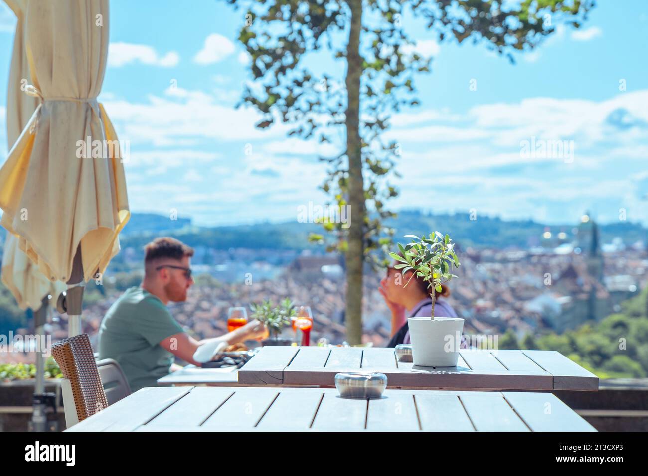 Bern, Switzerland–Aug 2,2023: young couple tourists enjoying under sunshine at an outdoor restaurant, vacation Stock Photo