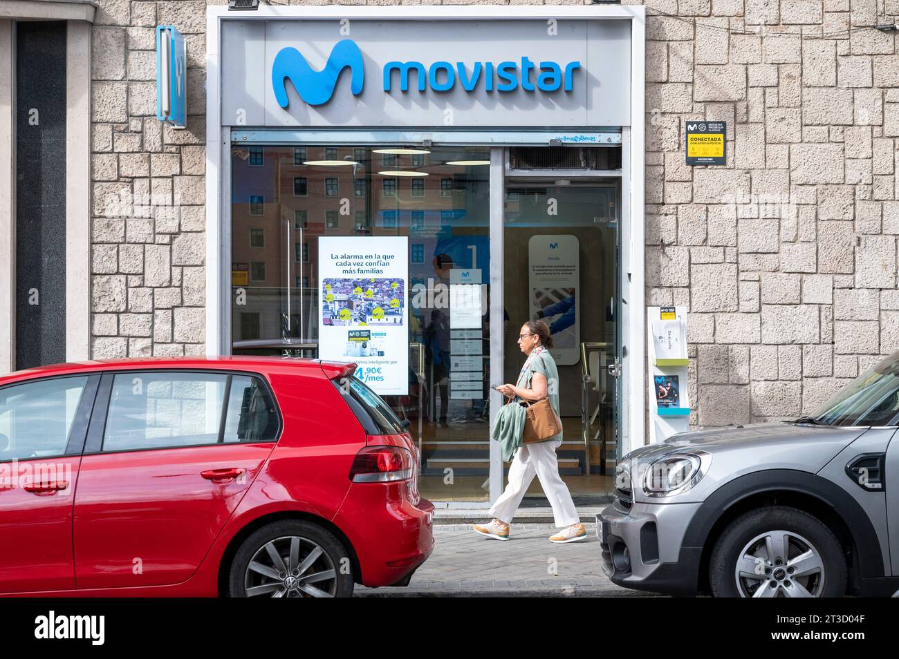 A pedestrian walks past the Spanish telecommunications brand owned by Telefonica and the largest mobile phone operator, Movistar, store seen in Madrid. Stock Photo