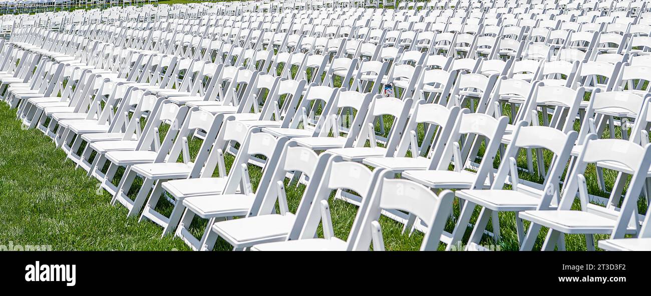 Rows of white folding chairs on green lawn Stock Photo - Alamy