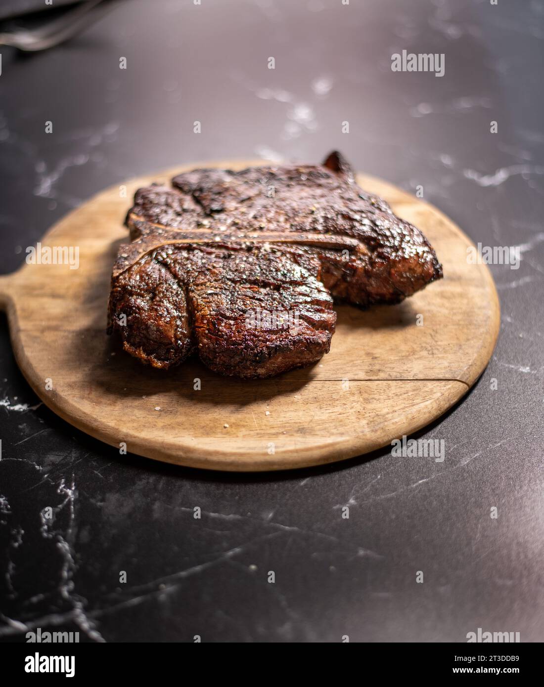 Sizzlling Portehouse steak on a wood board Stock Photo