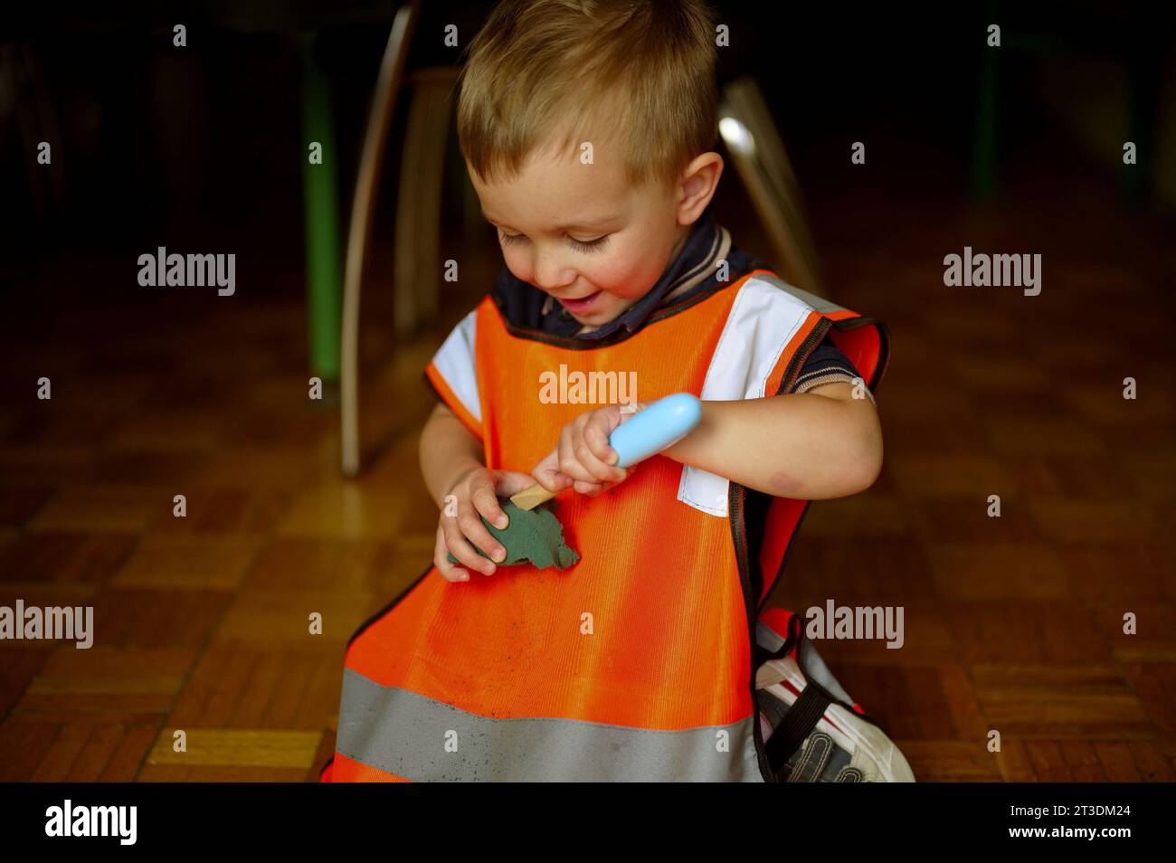 Little toddler dressed as a builder playing at home Stock Photo