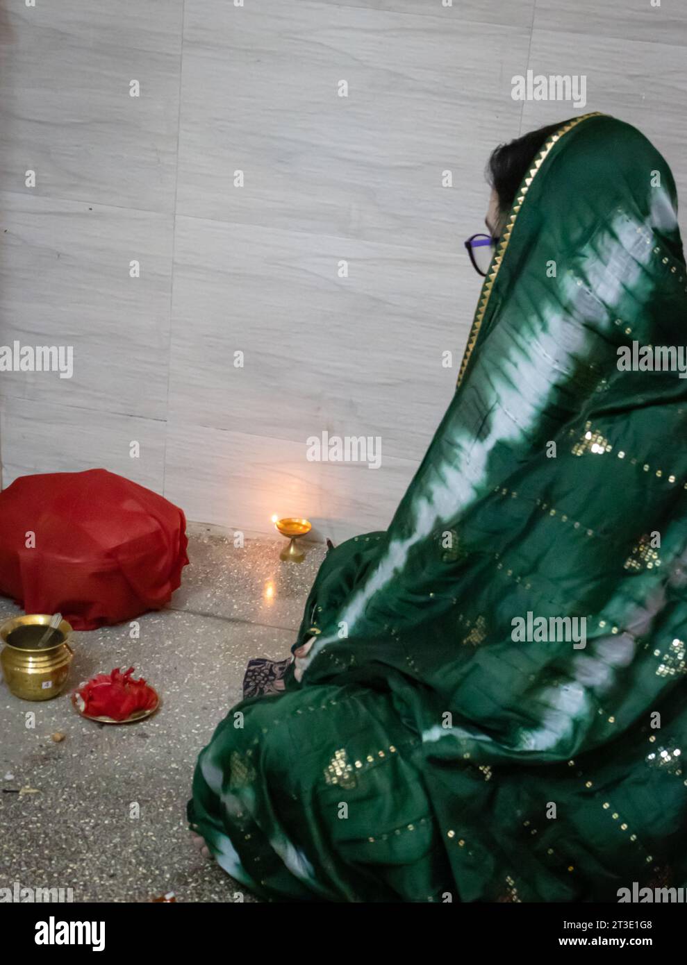 indian women doing holy rituals at home for children's wellbeing from different angle on the occasion of jitiya vrat or nirjala vrat in india. Stock Photo