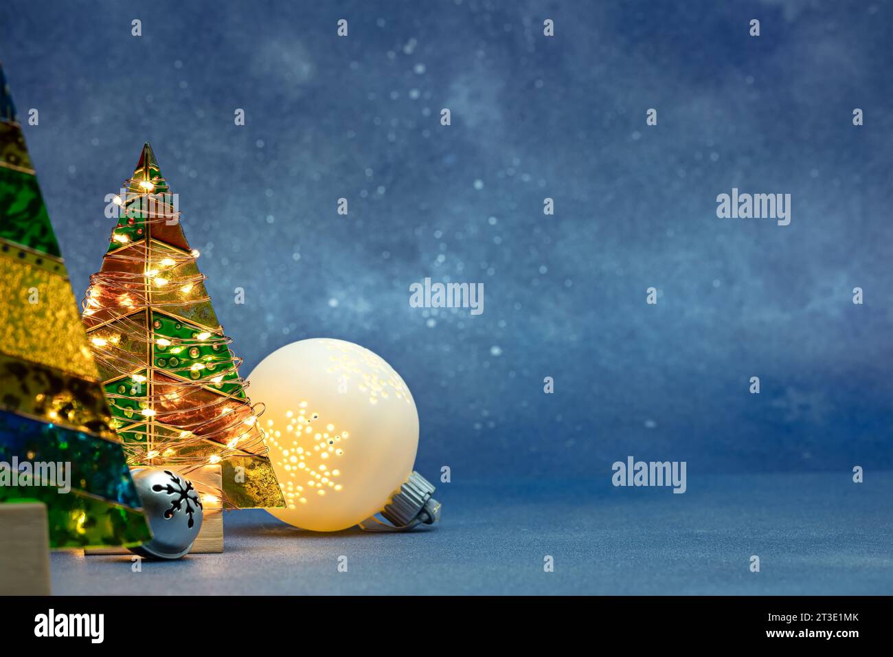 new year festive decorations on blue blurred background with illuminated christmas tree. Stock Photo