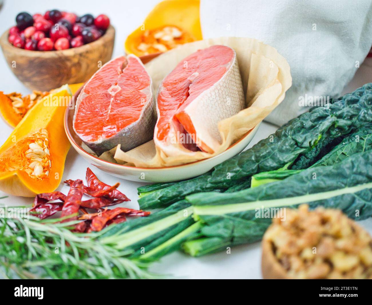 Colorful still life array of beautiful fall vegetable ingredients with sockeye salmon steaks for healthy eating or meatless, thanksgiving with fish. Stock Photo