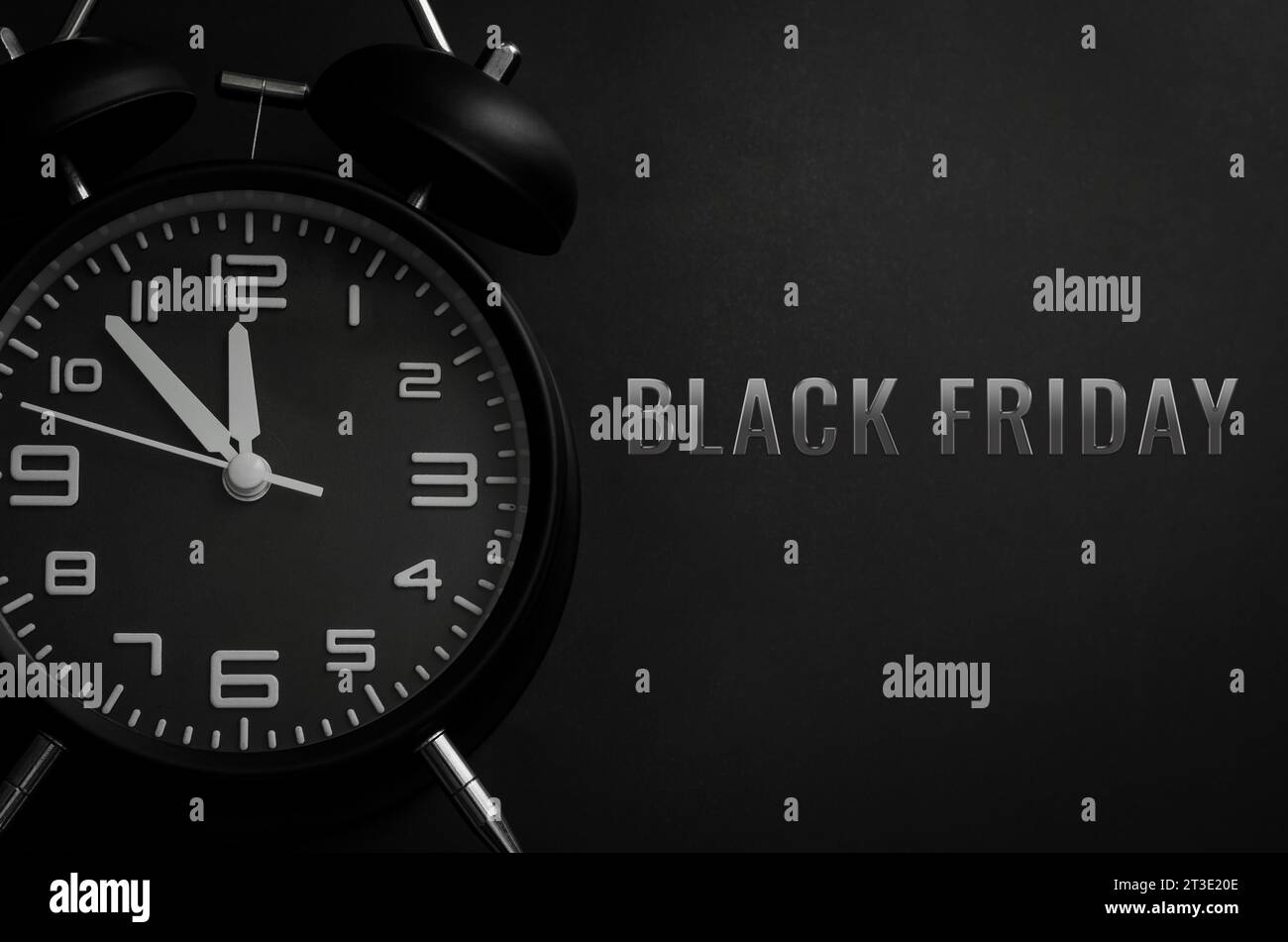 Black alarm clock with word Black Friday on black background for Black