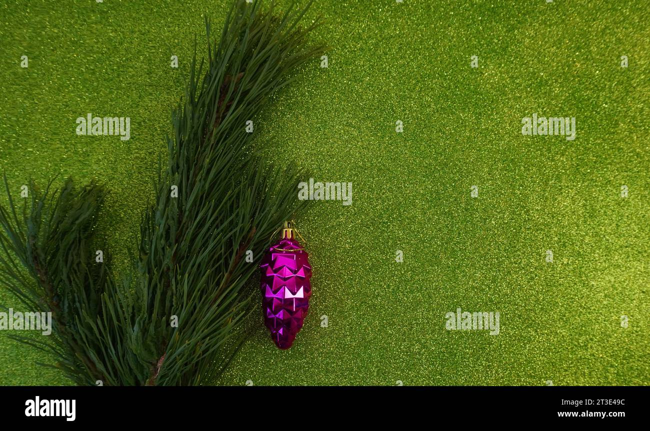 green christmas background with fir tree branch and christmas balls and ...