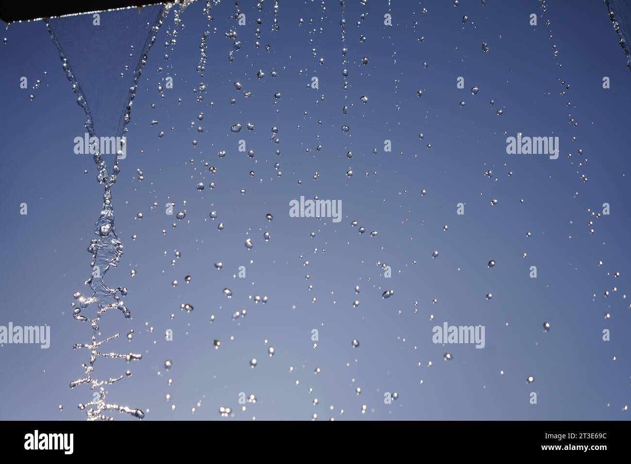 Water jet of a fountain against sunny blue sky in short-time-exposure Stock Photo