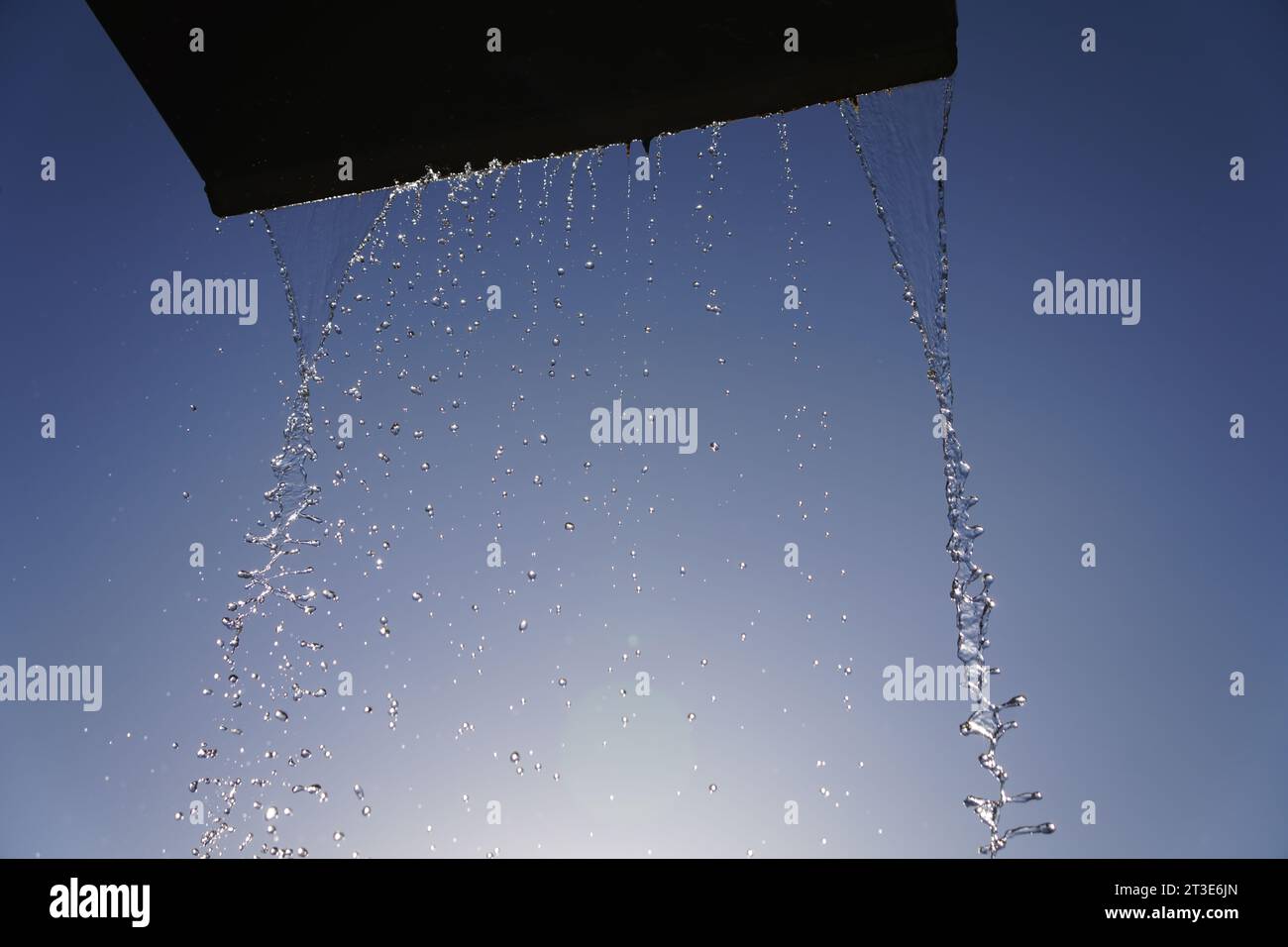 Water jet of a fountain against sunny blue sky in short-time-exposure Stock Photo