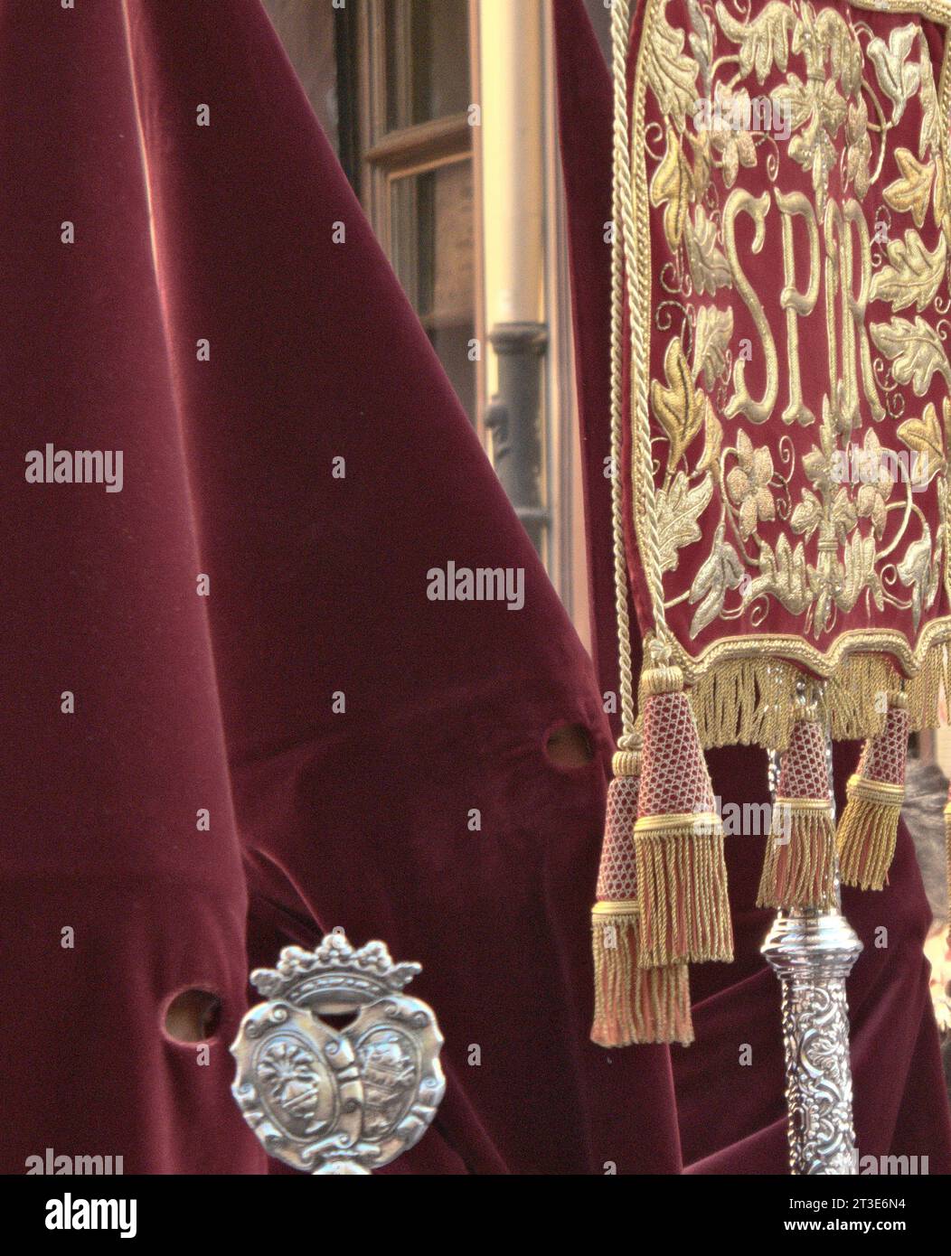 Two red pointed hat Capirotes with roman signs during Semana Santa in Granada Stock Photo