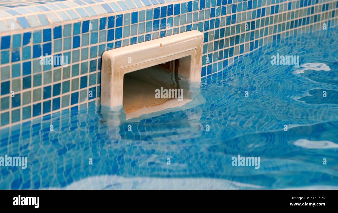 Dirty wall skimmer equipment filtration swimming pool system with reflection on blue water pool