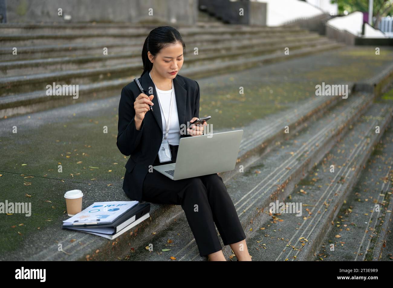 A focused and professional millennial Asian businesswoman in a formal ...