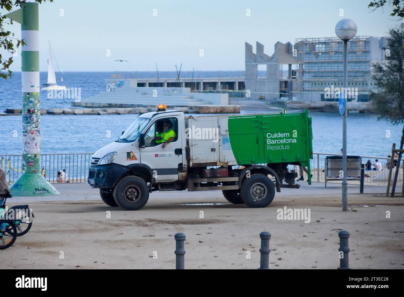 Municipal services, recycling collection. Municipal truck of waste management at beach. Barcelona, Catalonia, Spain. Stock Photo