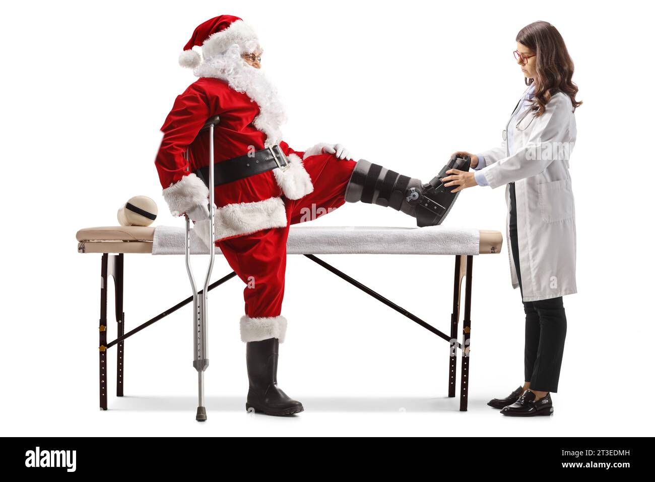 Female doctor checking santa claus with a foot brace and crutch isolated on white background Stock Photo