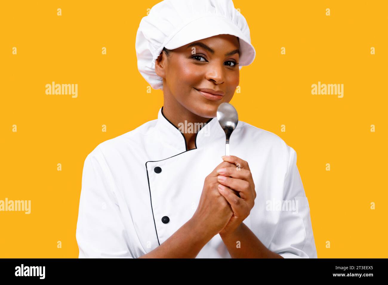 Smiling Young Black Chef Woman Using Spoon As Microphone Stock Photo