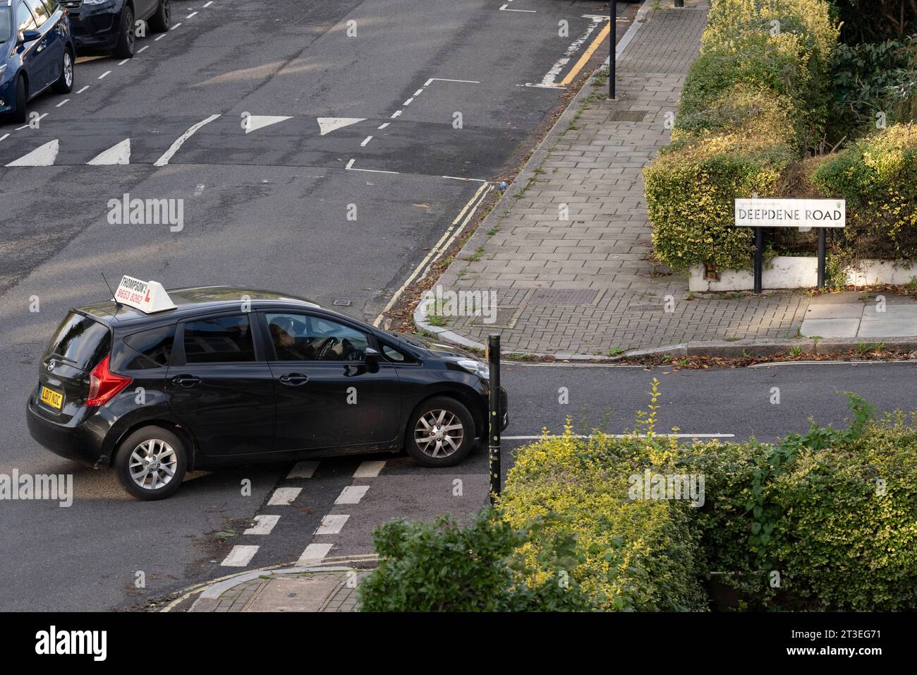 A learner driver taking lessons from an instructor cuts the corner off as they turn right on a residential street in Lambeth, south London, on 20th October 2023, in London, England. Stock Photo