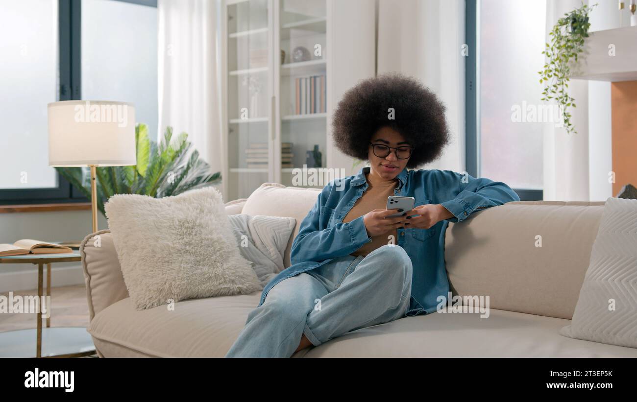 Relaxed calm African American ethnic woman typing swipe touchscreen ...
