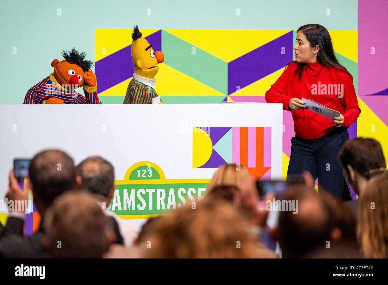 Munich, Germany. 25th Oct, 2023. Moderator Aline Abboud chats with the characters Ernie and Bert from the TV show 'Sesame Street' during the opening of the 37th Munich Media Days. One year after the revolutionary introduction of the AI chatbot ChatGPT, the German media industry came together in Munich to discuss artificial intelligence. The organizers are expecting a total of around 5,000 media professionals to attend the Medientage München - #MTM23 for short - which started on Wednesday. Credit: Lennart Preiss/dpa/Alamy Live News Stock Photo