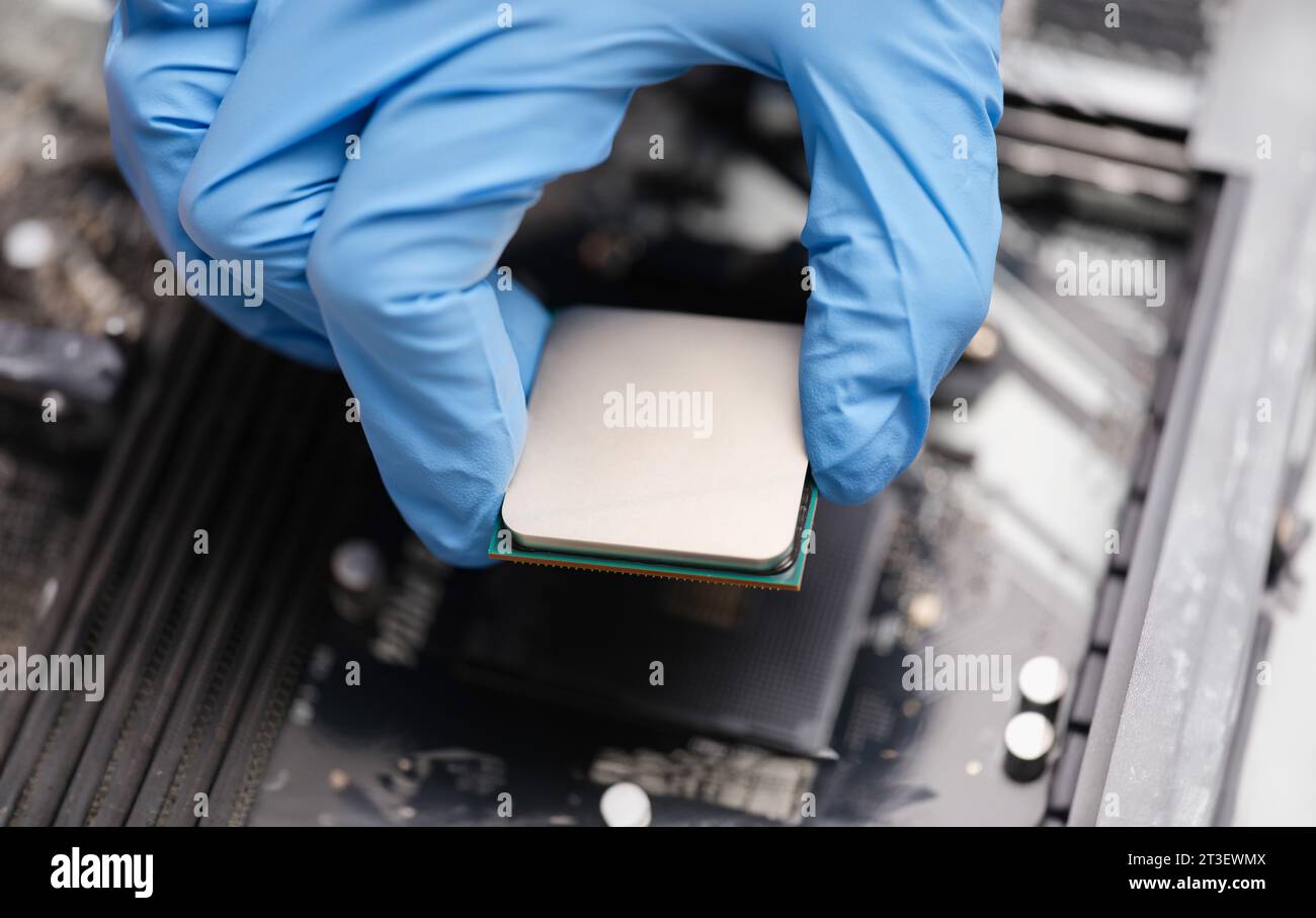 Handyman in rubber gloves installing computer processor closeup Stock Photo