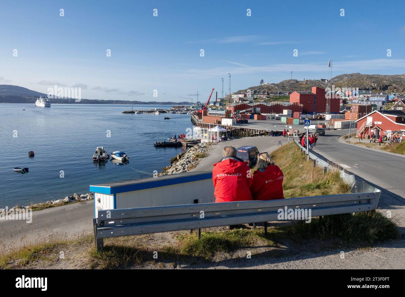 Cruise Ship Passengers Enjoy The Early Morning In The Town Of Qaqortoq Greenland, Looking At The Port Area Stock Photo