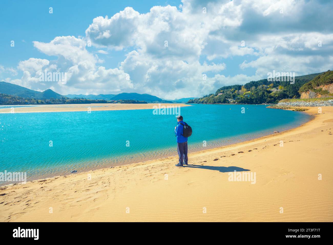 A tourist stands on the beach. Laida beach, Urdaibai biosphere reserve, Basque Country, Spain Stock Photo