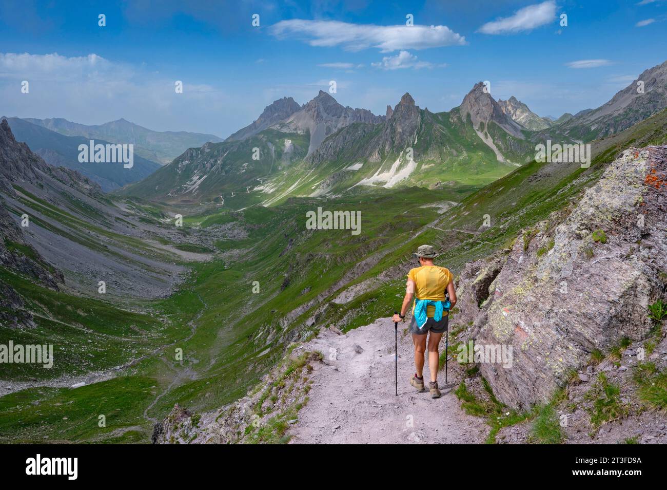 France, Savoie, Cerces massif, Valloires, hike towards Lac des Cerces, Col de la Ponsonnière, a hiker begins the descent and the Pic de la Ceinture and the Pointe de la Fourche Stock Photo