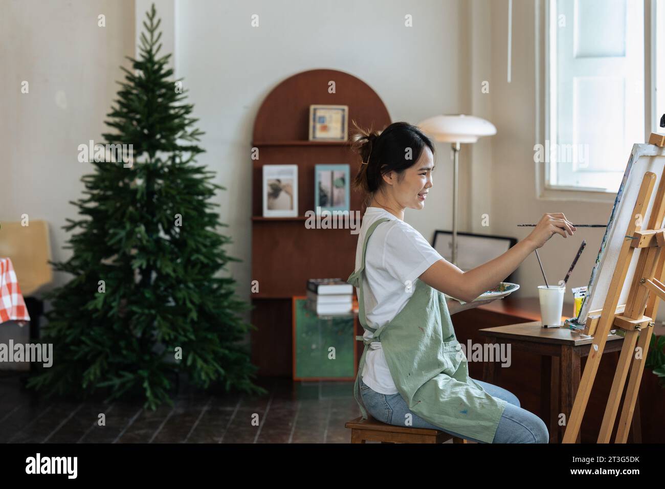 Female artist hold color palette and paintbrush for painting during ...
