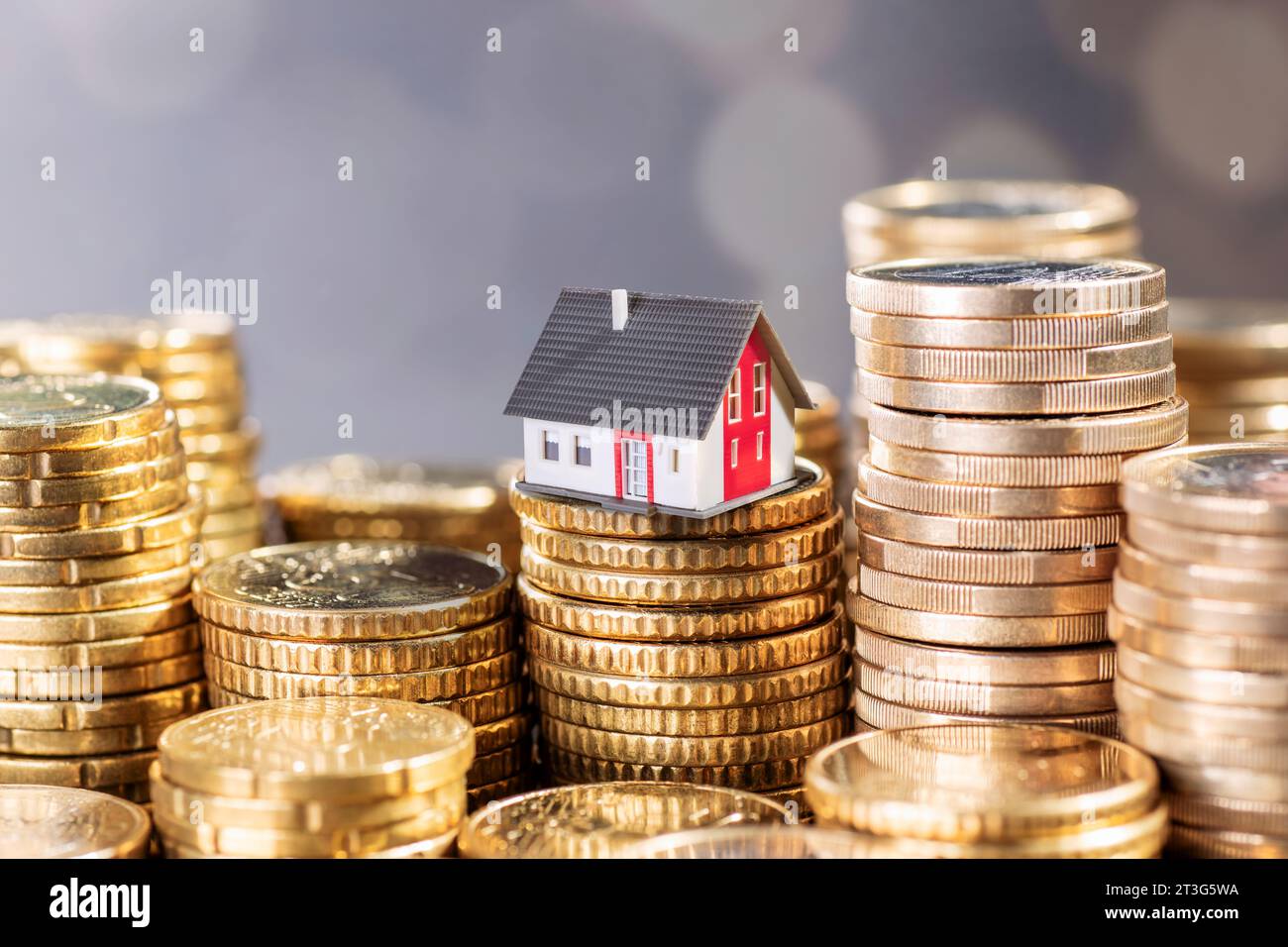 The cost of real estate. House with stacks of coins. Stock Photo