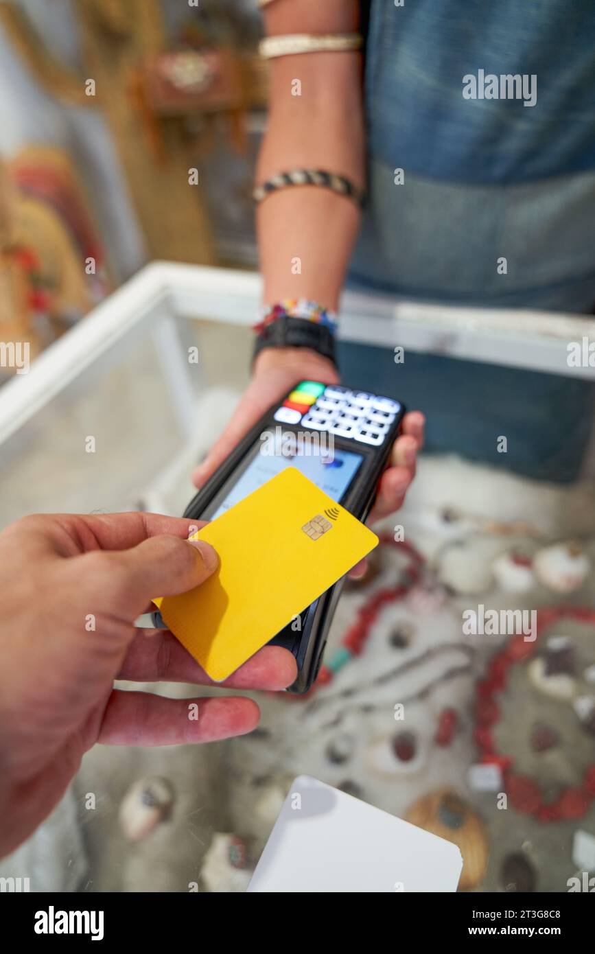 Close up of man's hand paying with card at a POS. Contactless payment. Stock Photo