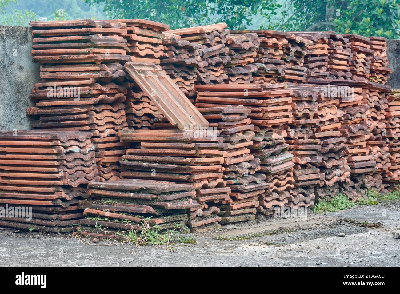pile of old used roof tiles, discarded red earthen roofing tiles arranged in outdoor Stock Photo