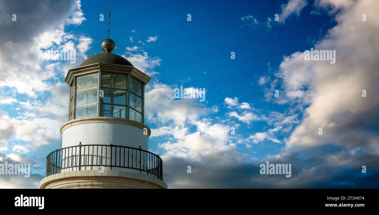 Gavdos Lighthouse, Crete island summer destination Greece. Upper part of old beacon monument surrounded by glass on cloudy sky background. Copy space Stock Photo