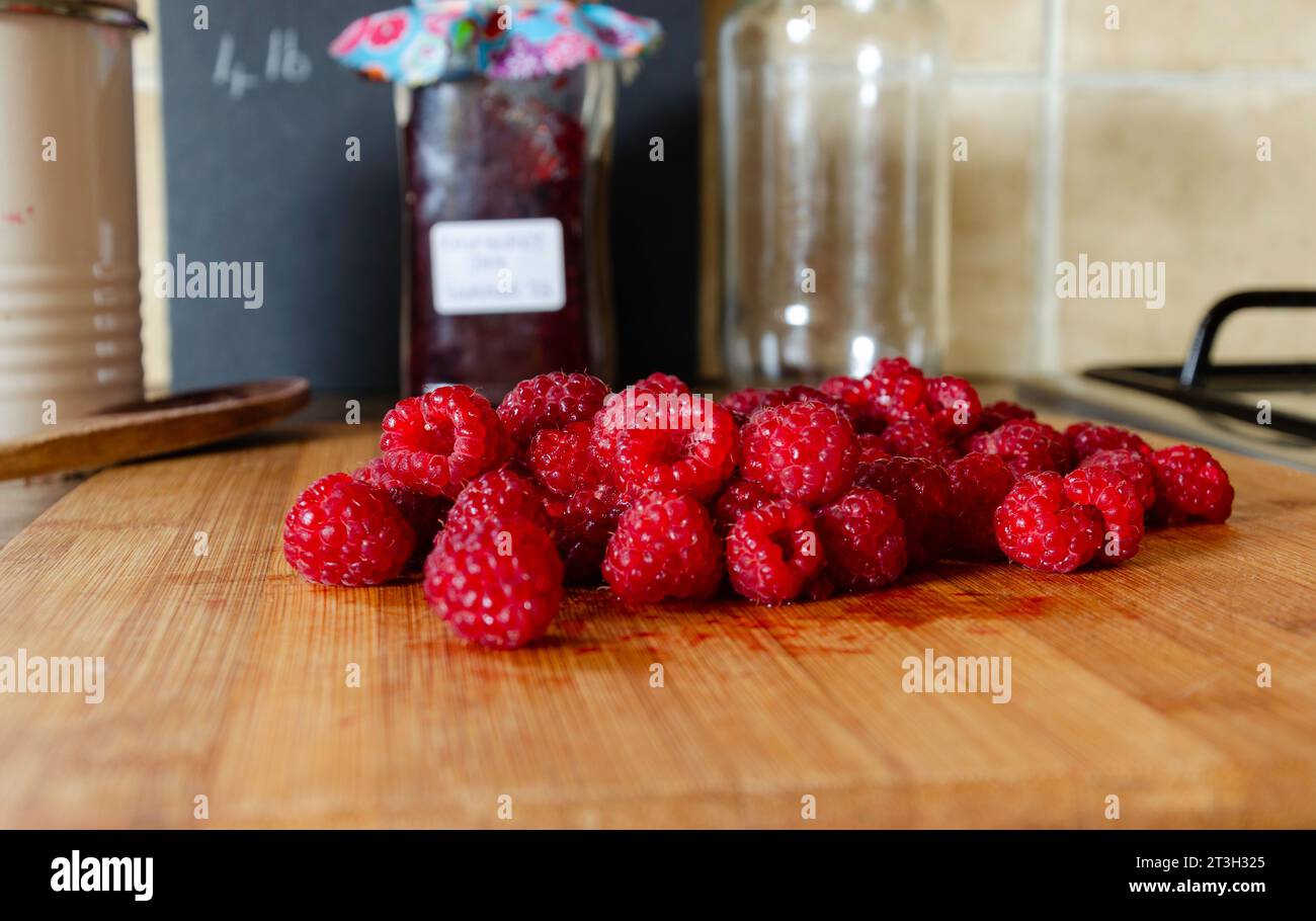 Red raspberries on a wooden board ready for making jam Stock Photo