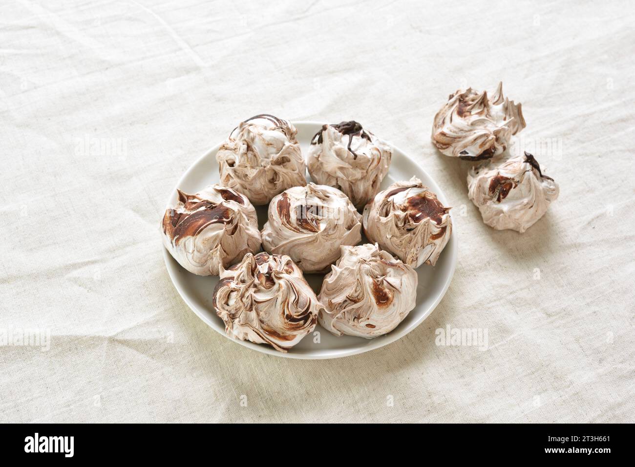Chocolate meringue cookies on plate over light background. Close up view Stock Photo