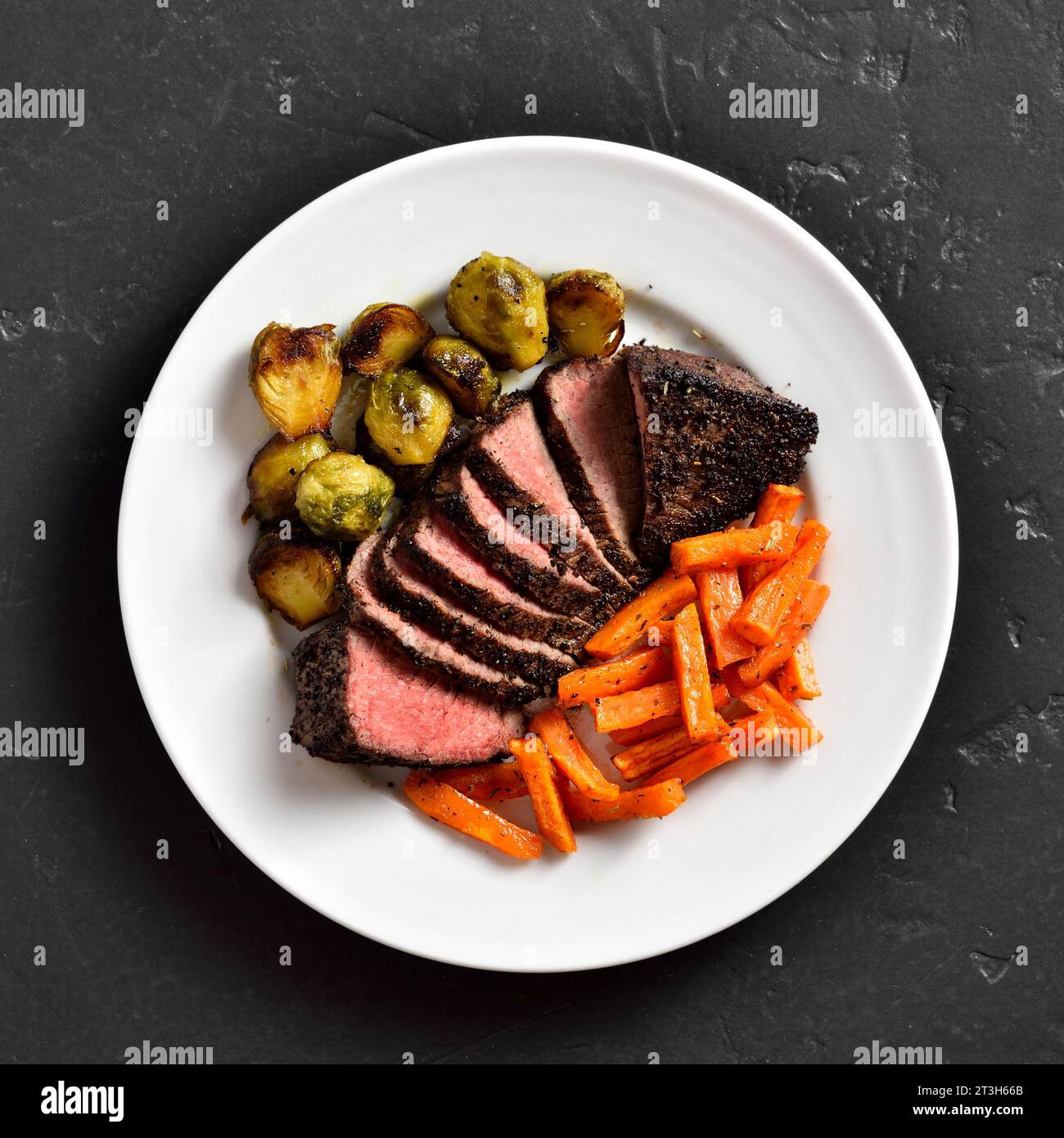 Grilled beef steak with brussels sprouts and sweet potatoes on plate