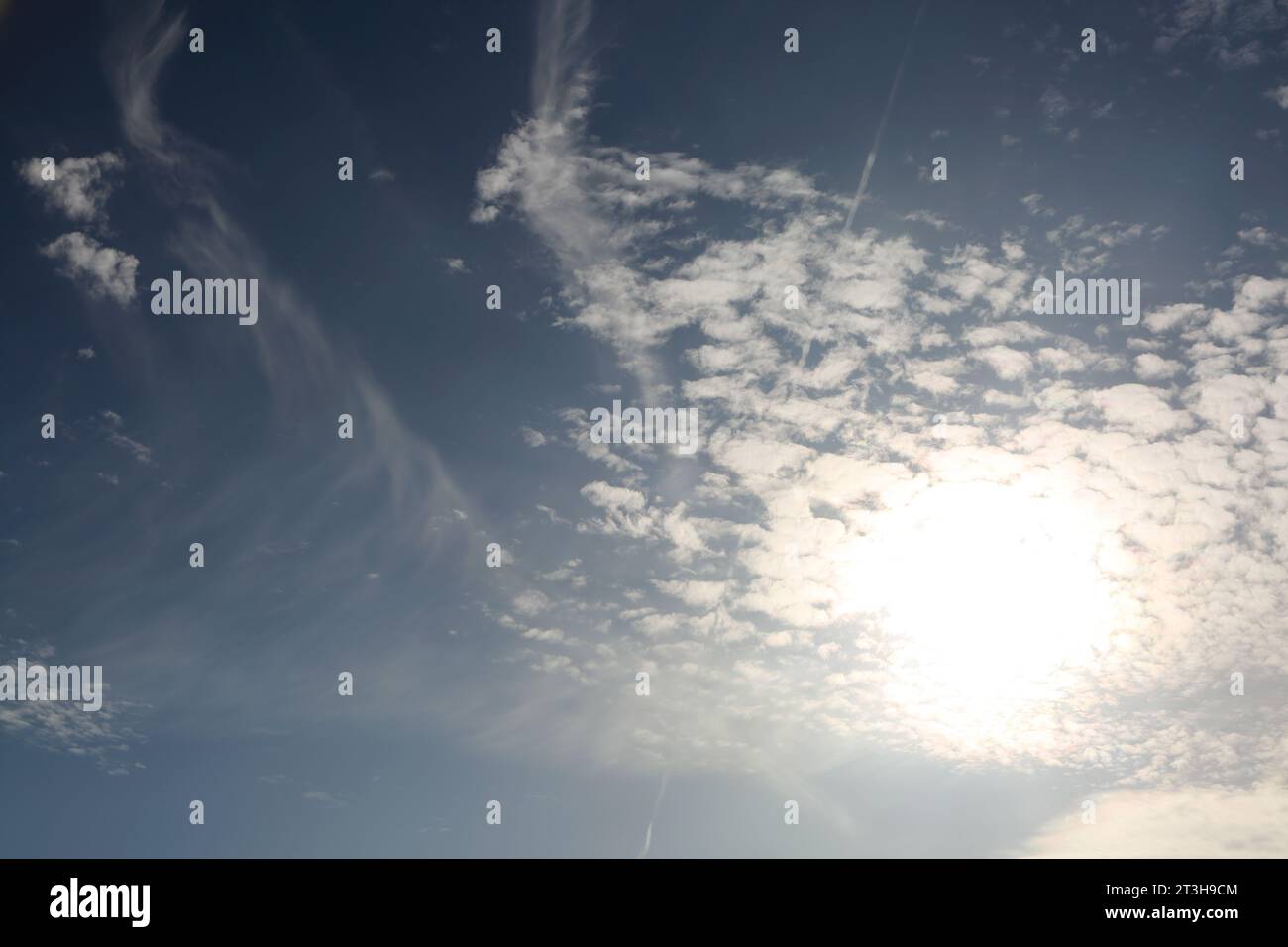 Sun Behind Cirrus and Cirrocumulus Clouds Stock Photo